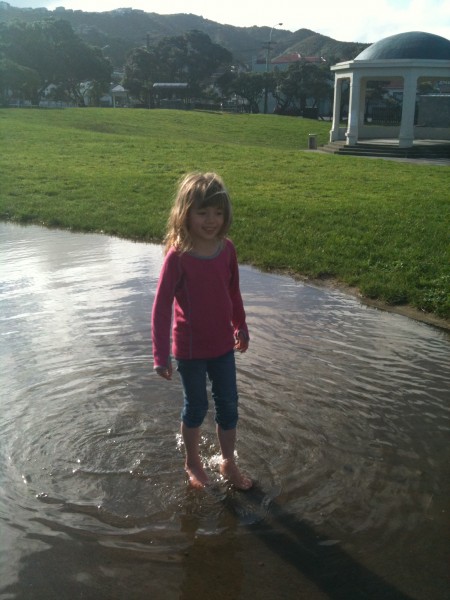 Charlotte wading through a giant puddle at Island Bay