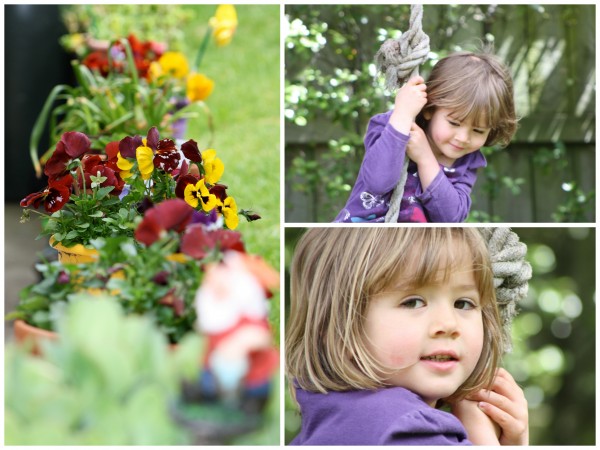 Sophie happy swinging whilst the garden gnome basks in colourful pansies