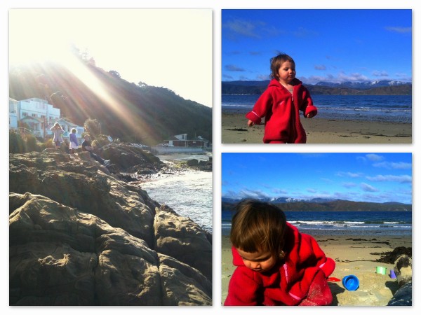 Cafe at Scorching Bay in background and Alice loving the sand in her winter play suit!