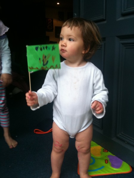 Alice waves her big sister Charlotte off to school with her flag made by Sophie