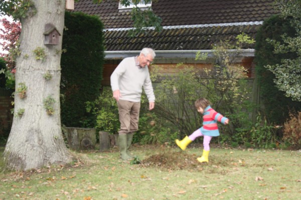 Kicking up leaves in English country garden with Granddad