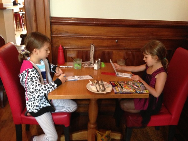 Sisters playing a game over lunch in a pub
