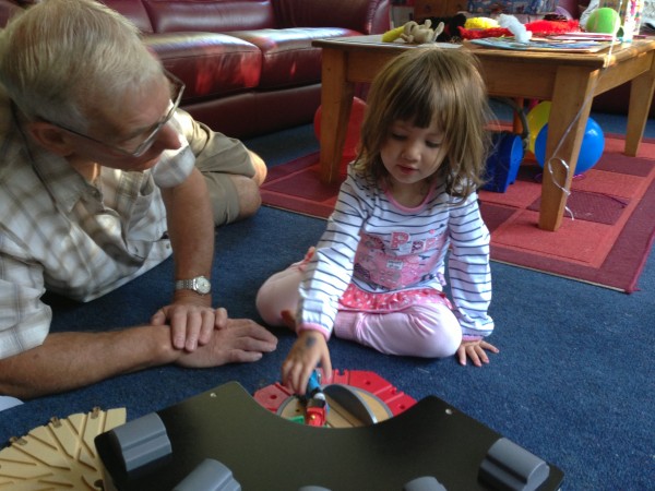 Granddad and Alice playing with the trains