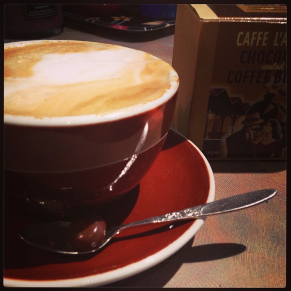 Morning latte with a chocolate coated coffee bean