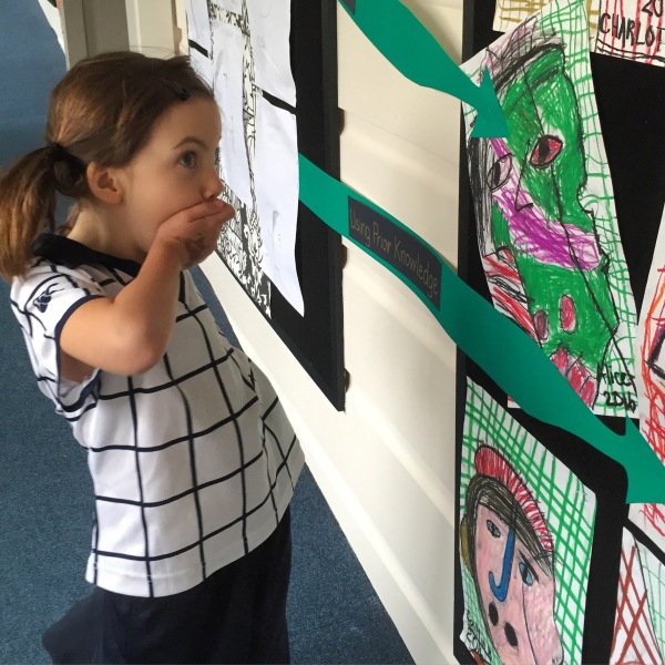 Alice delighted to see her artwork on display in school.