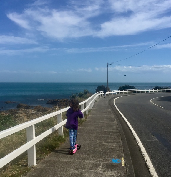 My youngest daughter, aged 6, scooting along past Houghton Bay, on Wellington's south coast