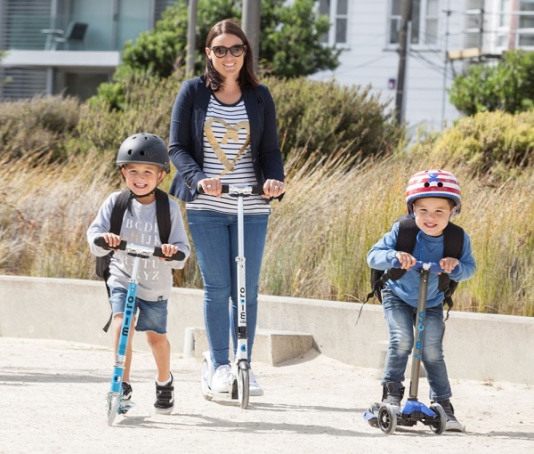 A mum scoots down Wellington waterfront with her two kids