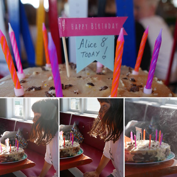 Alice blowing out her candles on the Birthday cake made by her sister, Sophie