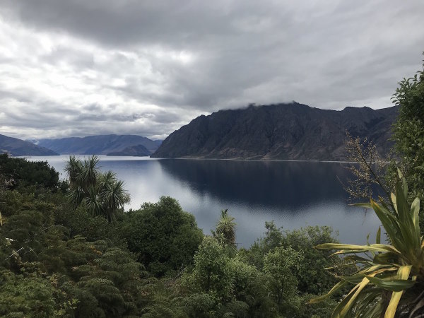 Beautiful reflections of the surrounding landscape in the quiet waters of Lake Hawea
